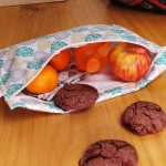 Pochette zippé entrouverte contenant des fruits et des biscuits